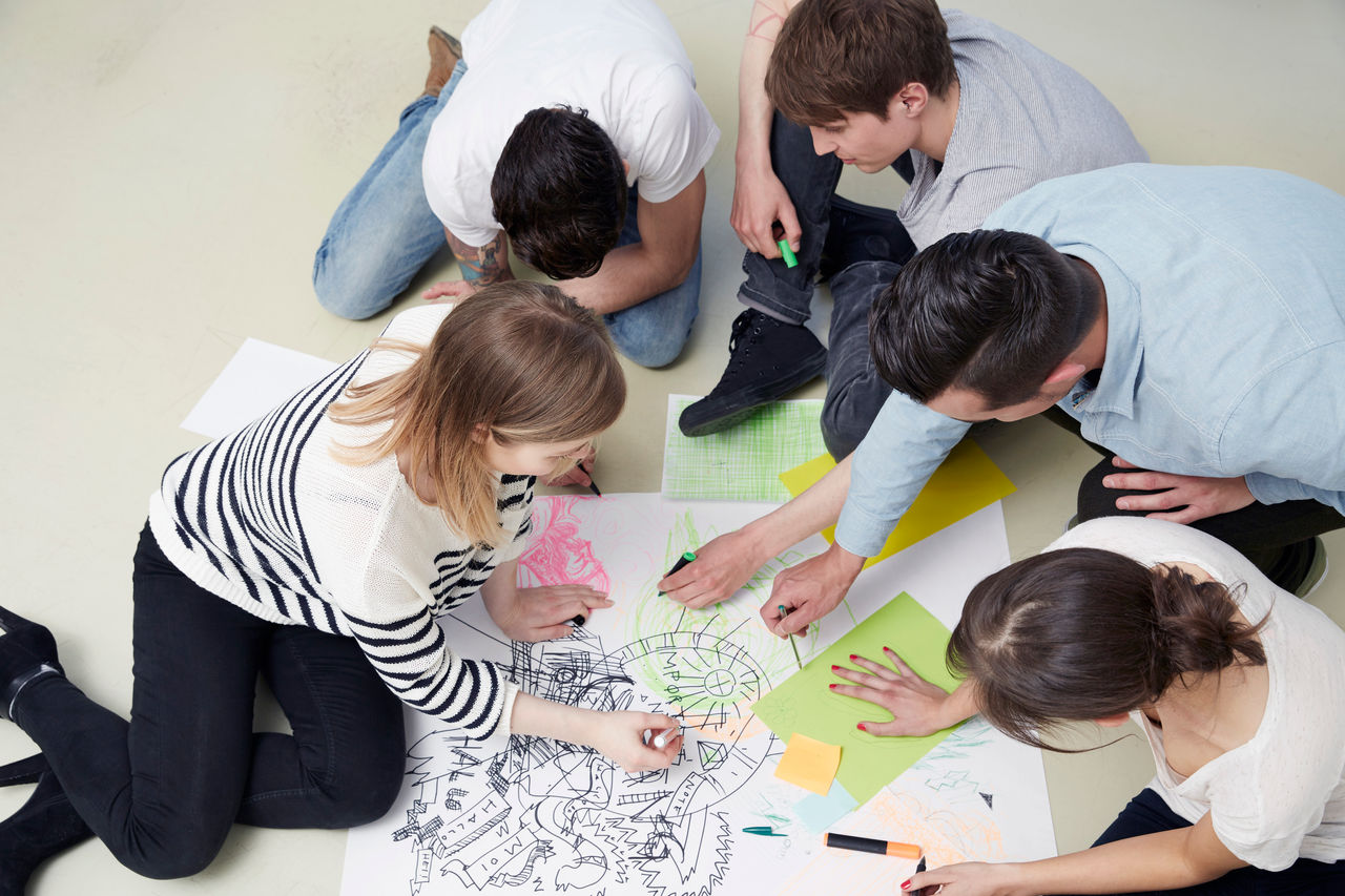 Group of creative professionals working on floor